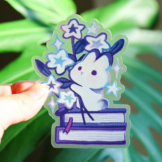 sticker of a rabbit sitting on books and holding a bouquet of stars