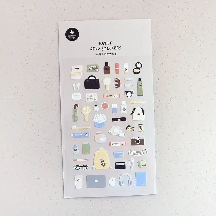 Suatelier No. 1155 In My Bag is a sticker sheet packed with everyday items you can't live without: makeup and skincare essentials, electronics, accessories, and more on a white background