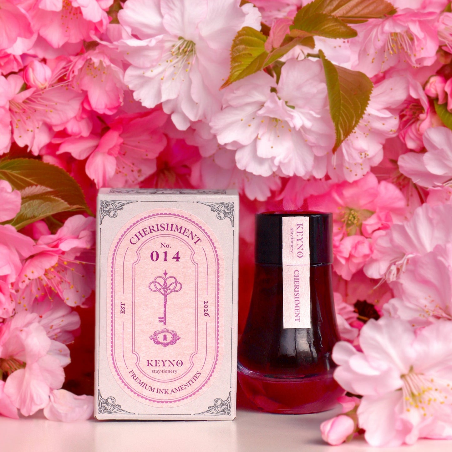 Dominant Industry Cherishment Key No. 14 fountain pen ink in a 25ml lightbulb-shaped glass bottle, muted dusty rose pink ink visible inside next to its box