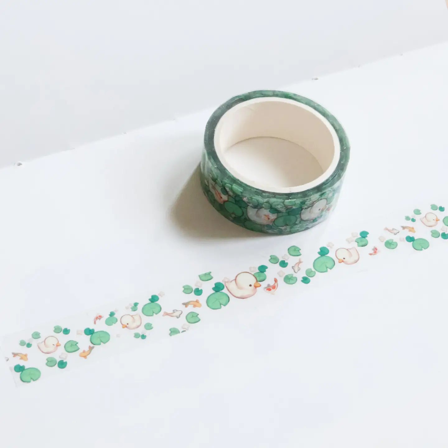 A Lost Duckling transparent PET tape unrolled showing repeating duck koi pond design