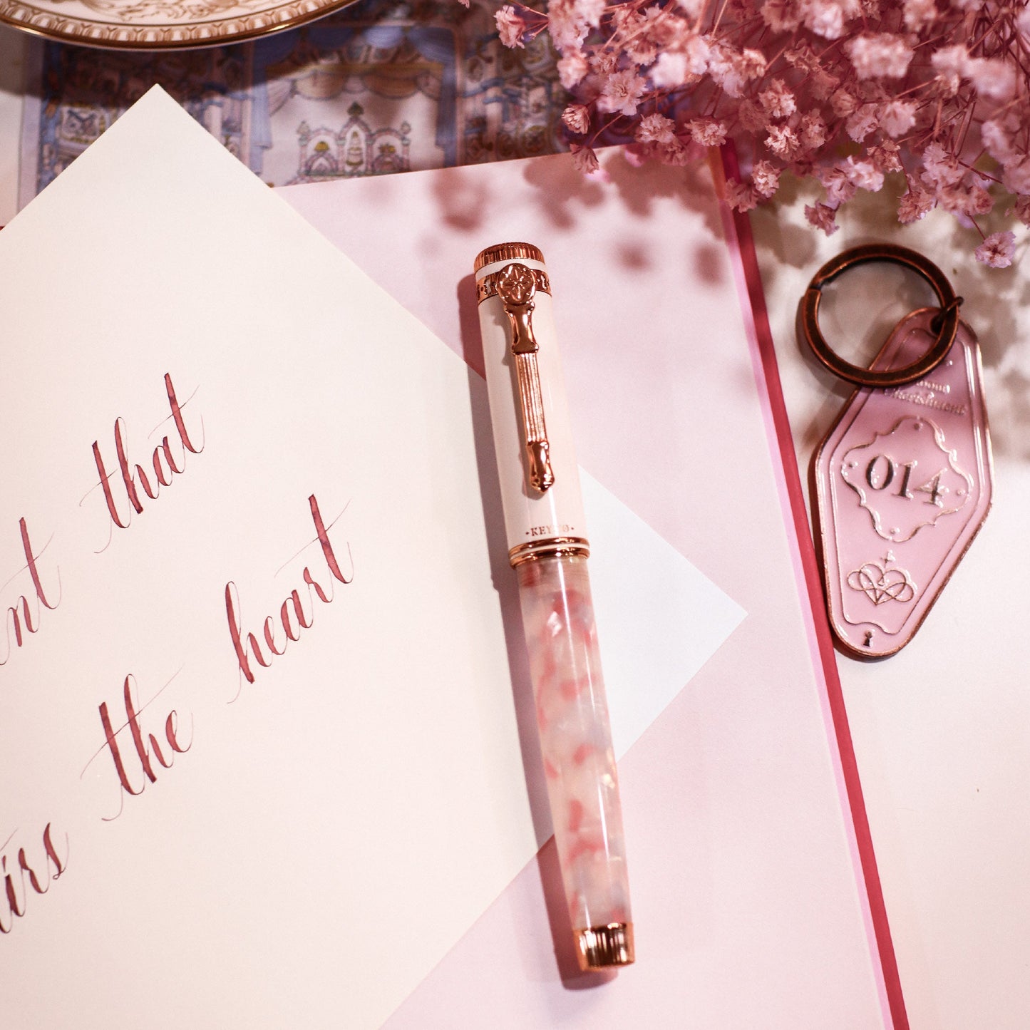 Keyno.Stationery No.14 Cherishment fountain pen on a piece of paper written with No. 014 cherishment ink and the included keychain/ keyring
