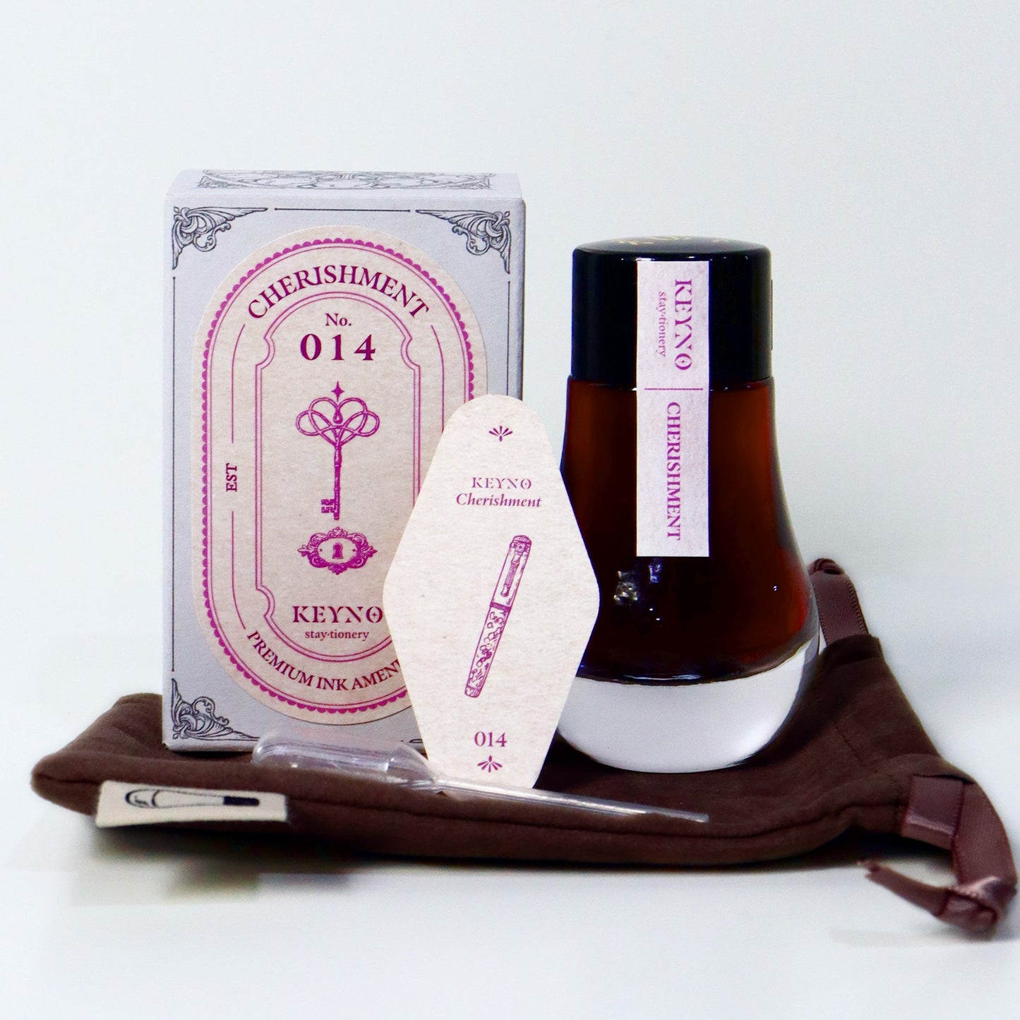 Dominant Industry Cherishment Key No. 14 fountain pen ink in a 25ml lightbulb-shaped glass bottle, muted pink ink visible inside next to its box and the official ink card. 