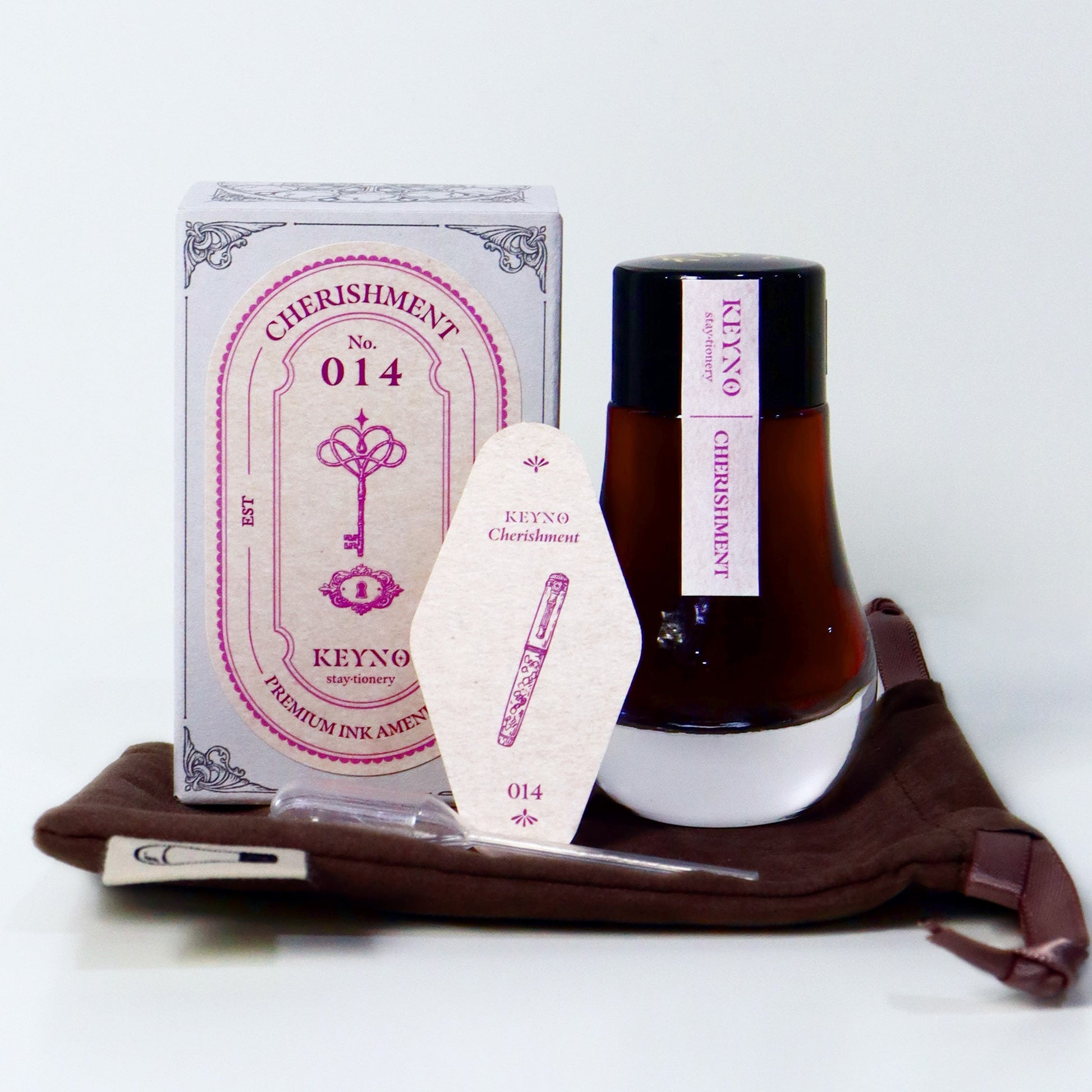 Dominant Industry Cherishment Key No. 14 fountain pen ink in a 25ml lightbulb-shaped glass bottle, muted pink ink visible inside next to its box and the official ink card. 