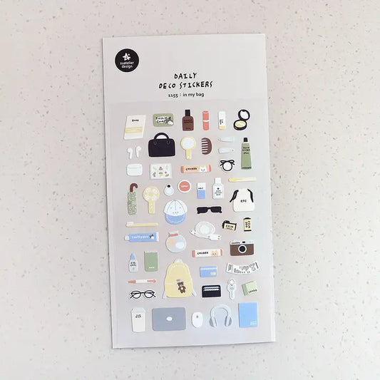 Suatelier No. 1155 In My Bag is a sticker sheet packed with everyday items you can't live without: makeup and skincare essentials, electronics, accessories, and more on a white background