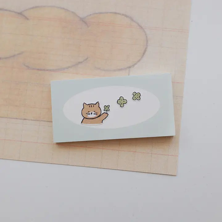 Goyami blowing a four leaf clover on a notepad 