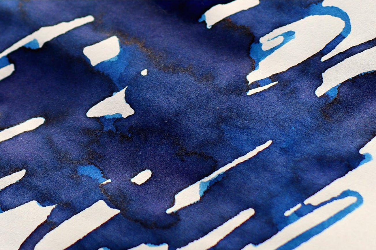 Dominant Industry blue rose calligraphy ink in a 25ml bottle on a map and a swatch of the ink
