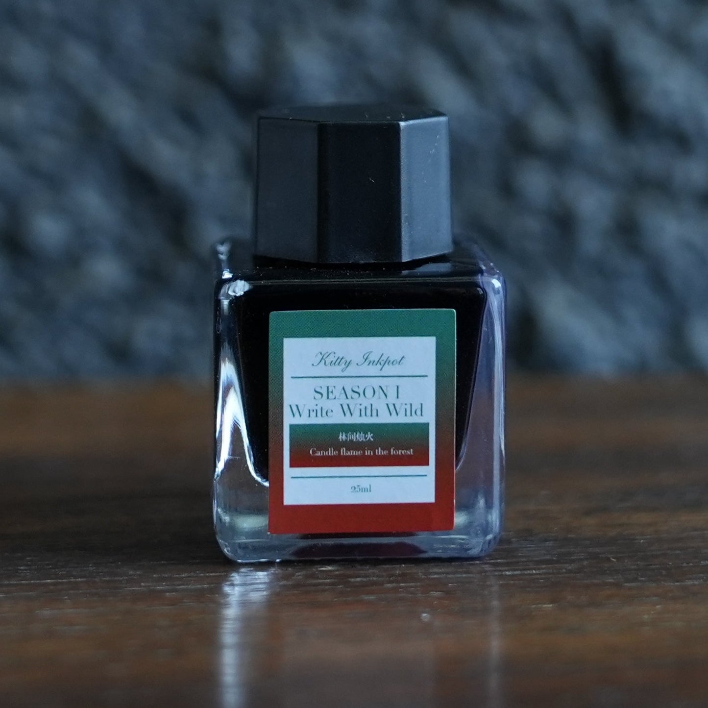 A bottle of kitty ink pot candle flame in the forest fountain pen ink on a desk