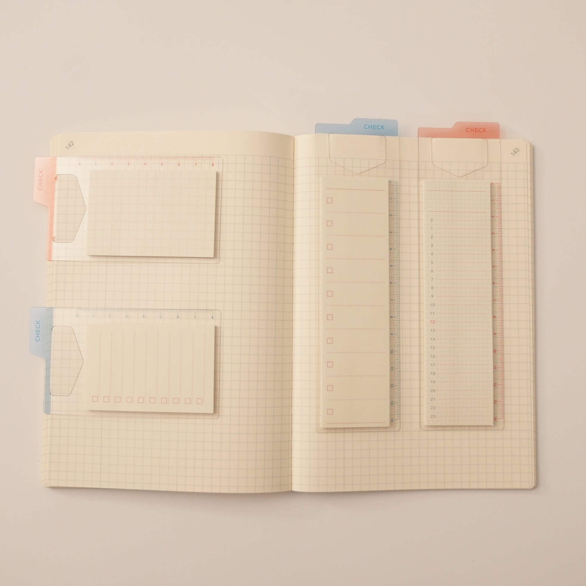 Isshoni. Bookmark Index Sticky Notes. One mounted on a blue ruler bookmark with a to-do list, the other mounted on a red ruler bookmark with a daily schedule and their mini counter parks in a daigo notebook