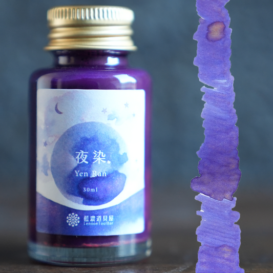 Lennon Tool Bar Yen Ran ink on a wood desk next to the purple shimmer swatch. Royal purple with gold shimmer. 30ml 