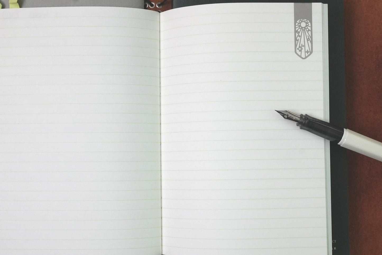 LIFE Pistachio Notebook in B6 held open by Midori Weather Book Marker and next to a Pilot Kakuno panda fine fountain pen.